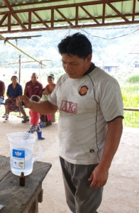 Figure 1. A community member applying his training in chlorinating water