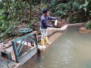 Figure 2. A water sample being taken from a water offtake dam from which water gravitates to a community